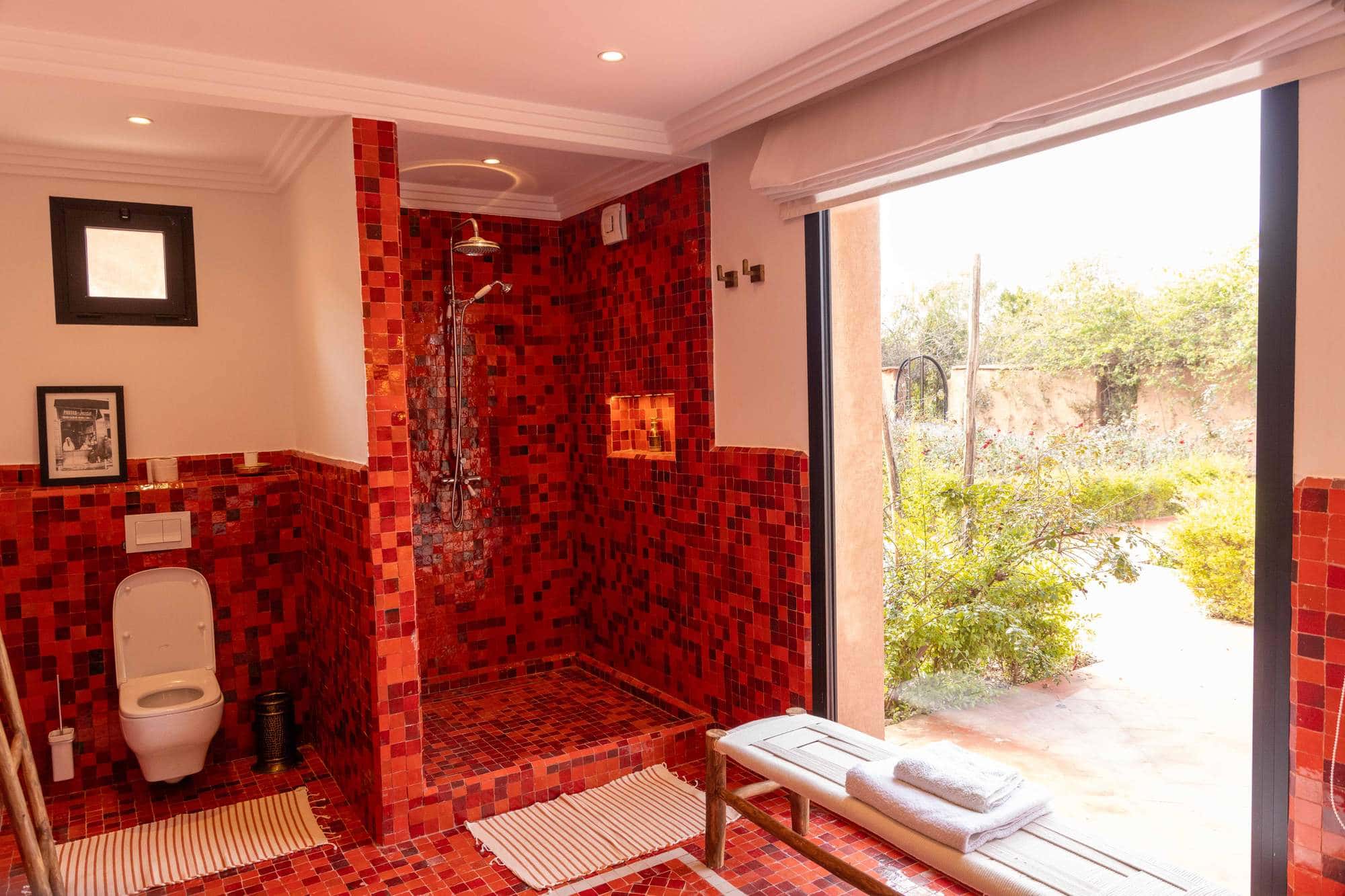 Imlil Suite at Villa Yemna in Marrakech, bathroom with red shower, garden view.