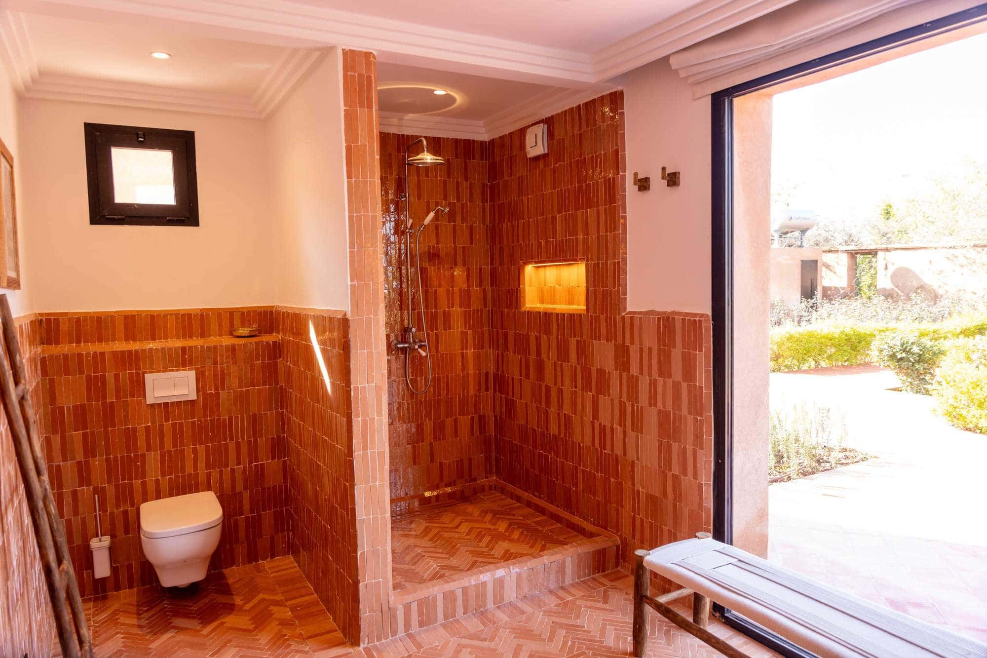 Ourika Suite at Villa Yemna in Marrakech, bathroom with terracotta-tiled shower, exterior view.