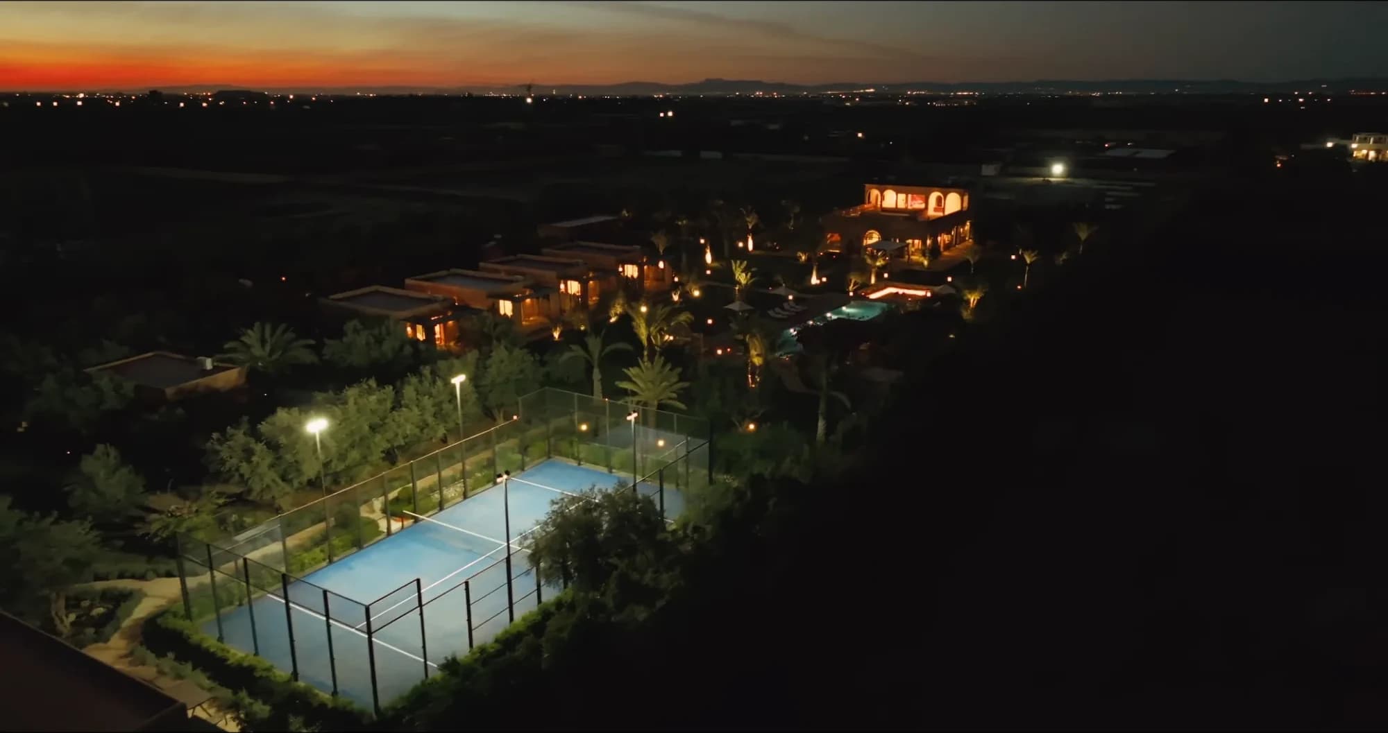 Aerial twilight view of the padel court and pool at Villa Yemna